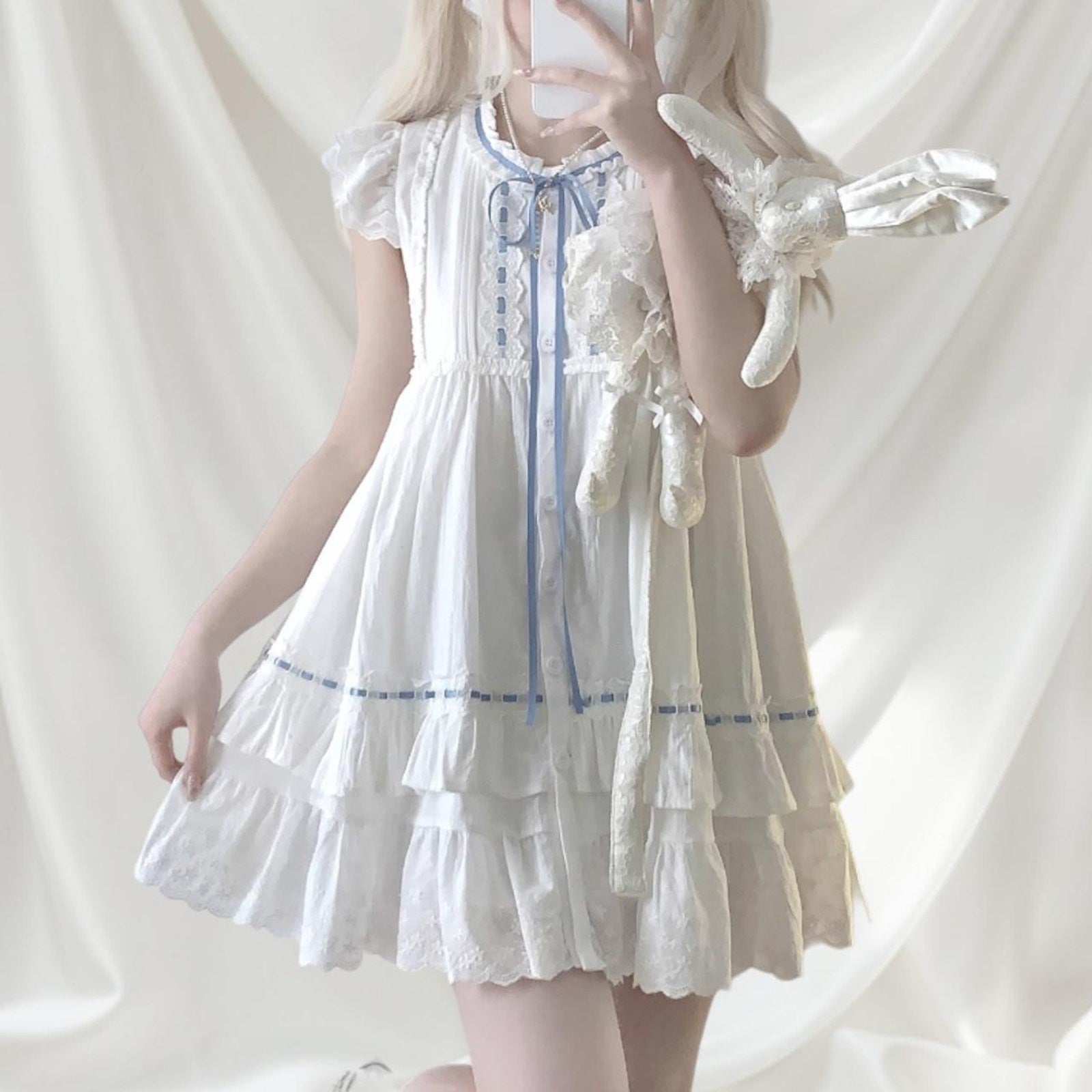 White cotton dress with blue ribbon and lace detail0