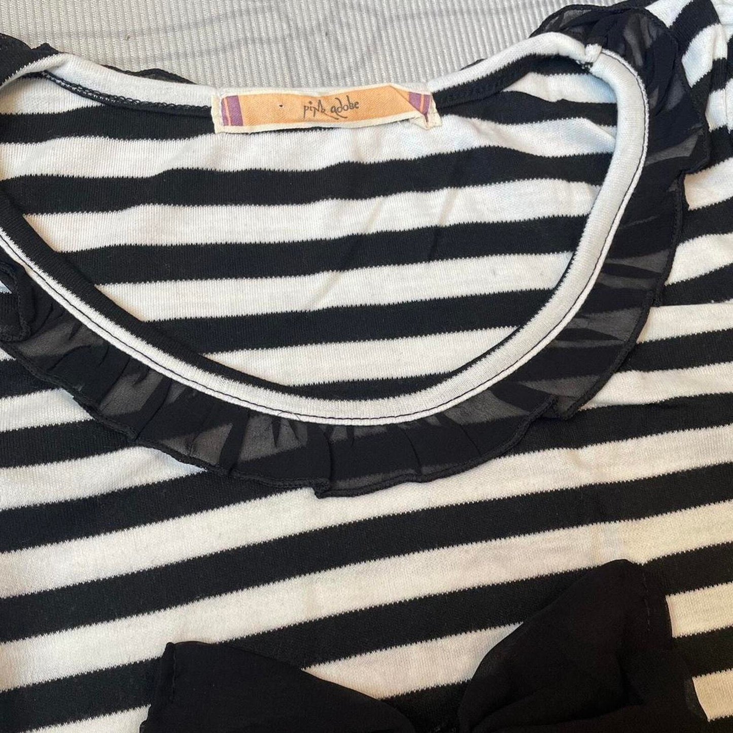 Black and white striped top with black bow and ruffled neckline 1
